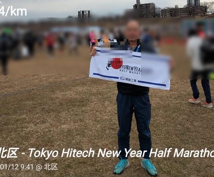 ハーフマラソン会場で記念タオルを掲げる